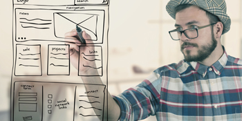 Man at a whiteboard drawing a webpage layout Man at a whiteboard drawing a webpage layout