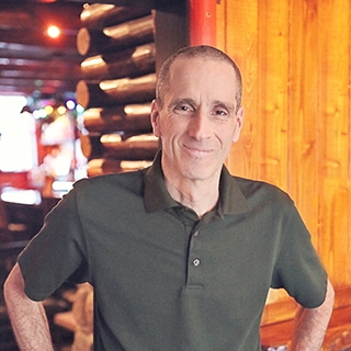 The author standing in front of a log cabin
